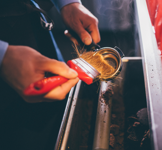 Coffee grounds being removed from coffee tamper